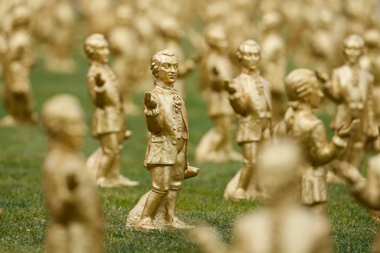 People walk by some of the 400 gold colored plastic Mozart sculptures by German artist Ottmar Hoerl from Nuremberg for the 270th birthday of composer Wolfgang Amadeus Mozart in Salzburg, Austria, Wednesday, July 15, 2026. (AP Photo/Matthias Schrader, File)